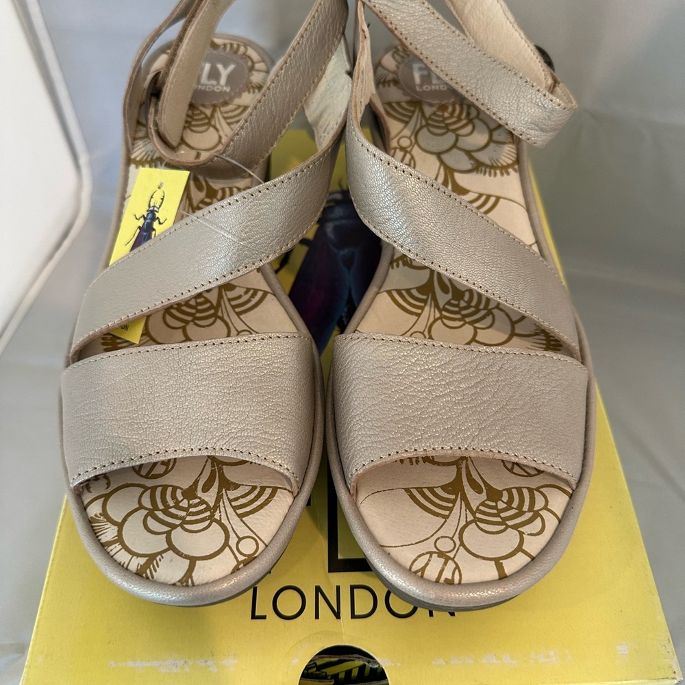 Fly London Yesk Sandal Wedge in the color silver.